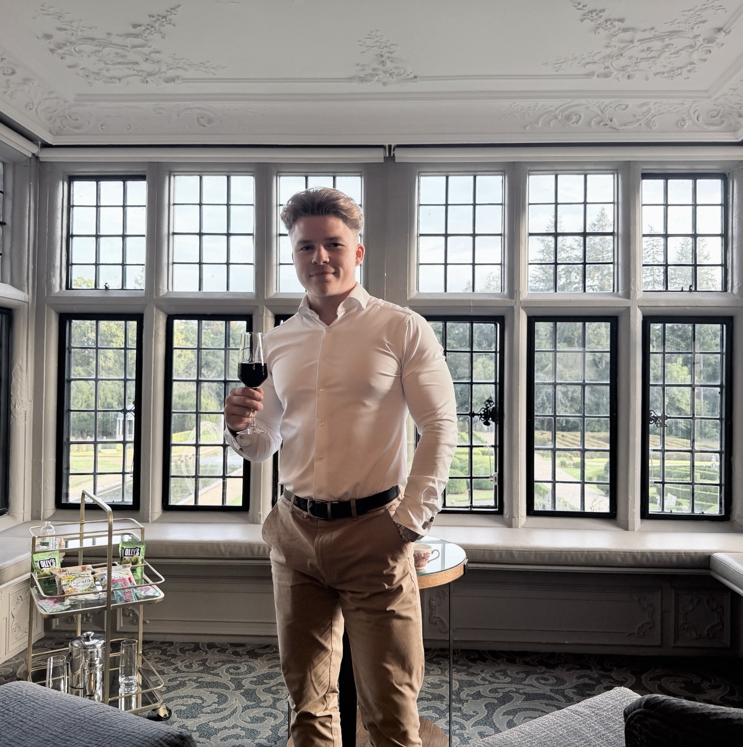 Ryan Shuckford, founder of GHOST, standing in front of large windows in a white shirt